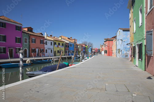 Typical canal with colorful facades with vibrant colors in famous fishermen village on the island of Burano, Venice, Italy © Melanie