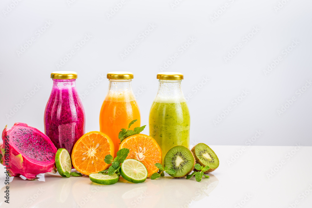 Three flavours of fruit juice in bottles with a straw islolated on white background with copy space. Three flavours of fruit juice in bottles with a straw islolated on white background with copy space.