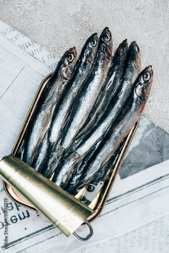 Top view of pile of fish in can on newspaper photo