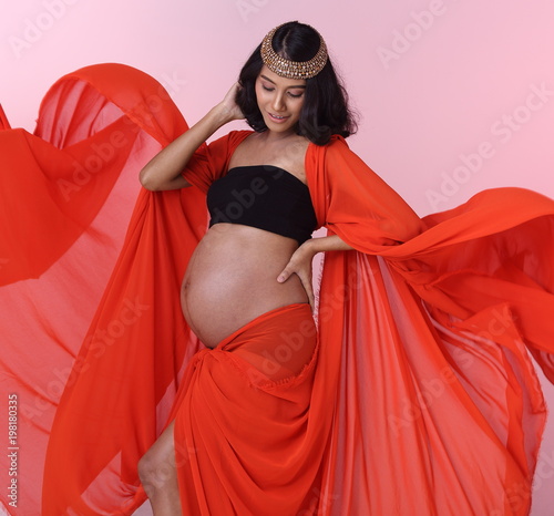 Portrait of Pregnant Asian Indian tanned skin woman fabric fluttering in Air