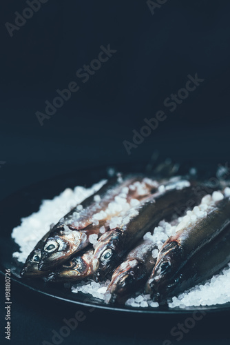 Pile of salted fish in frying pan isolated on black photo