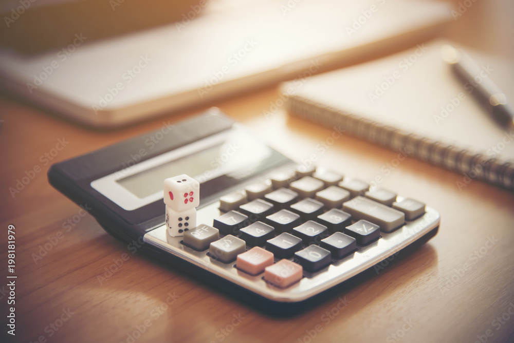tax text on dice with blurred calculator on wooden table. abstract background to tax concept. tax text on dice with blurred calculator on wooden table. abstract background to tax concept.