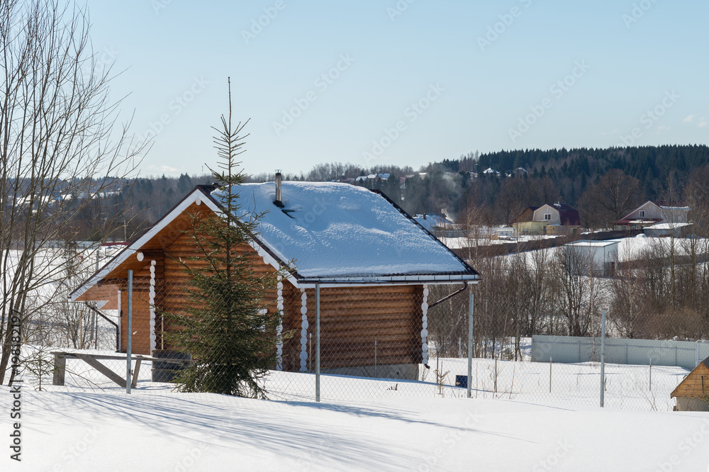Wooden house in village in sunny winter day