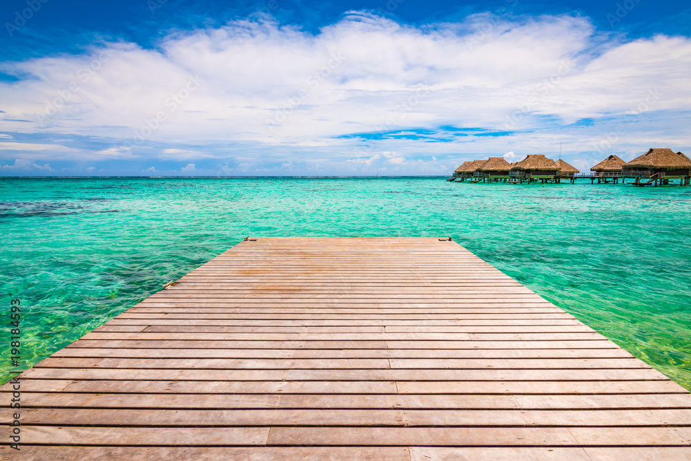 Wooden pier over tropical sea or blue lagoon. Paradise landscape. Summer vacation concept.