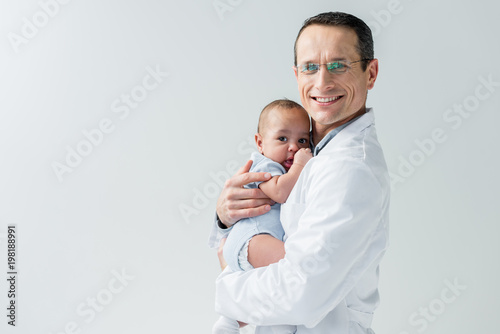 happy adult pediatrician holding little baby isolated on white photo