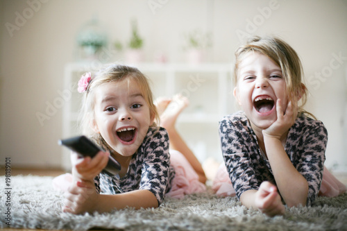 Little girls with remote at home.