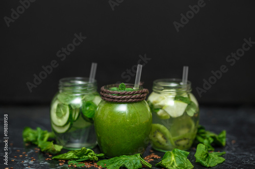 Blended green smoothie with ingredients on table