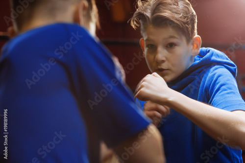 Two young  male boxers train in the ring for a fight