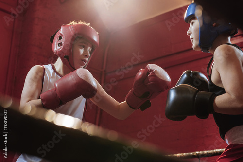 Two young male boxers fitting and training in the ring for a fight