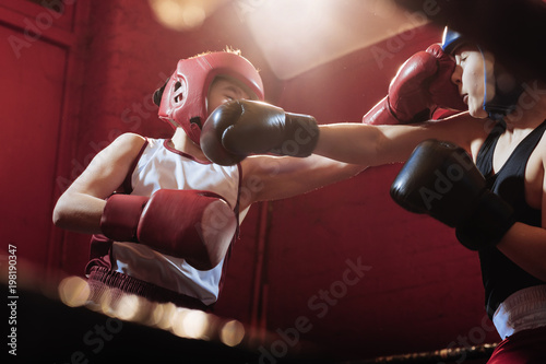 Two young male boxers fitting and training in the ring for a fight