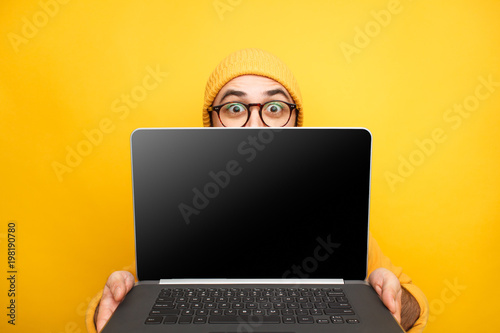 Playful man offering modern laptop
