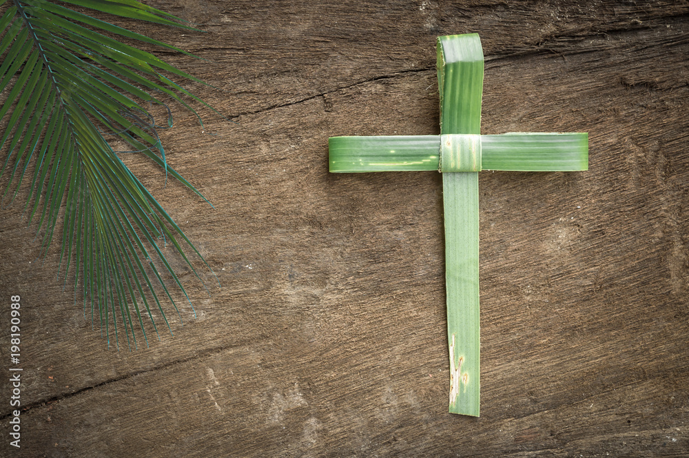 Palm sunday concept: Cross shape of palm branch on an antique wood