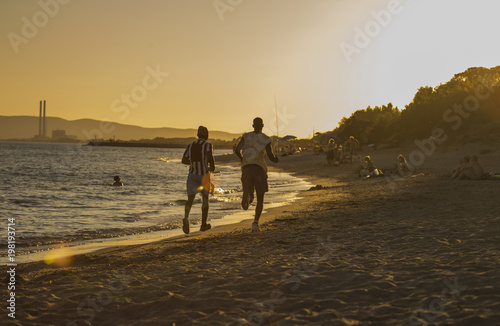 a couple of people running on the beach at sunset.jpg