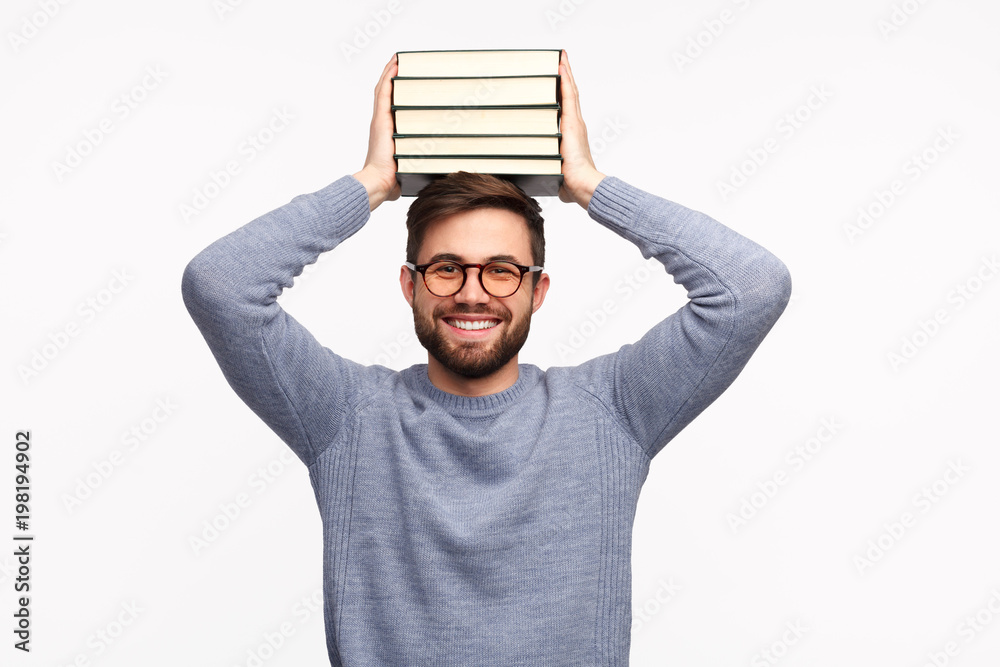 Smiling diligent student with stack of books - obrazy, fototapety, plakaty 