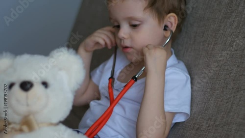 Baby with doctor's tools playing with teddy bear