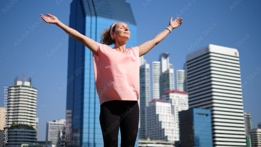 Happy Sport Woman In Wireless Earphones Raising Arms After Workout In City