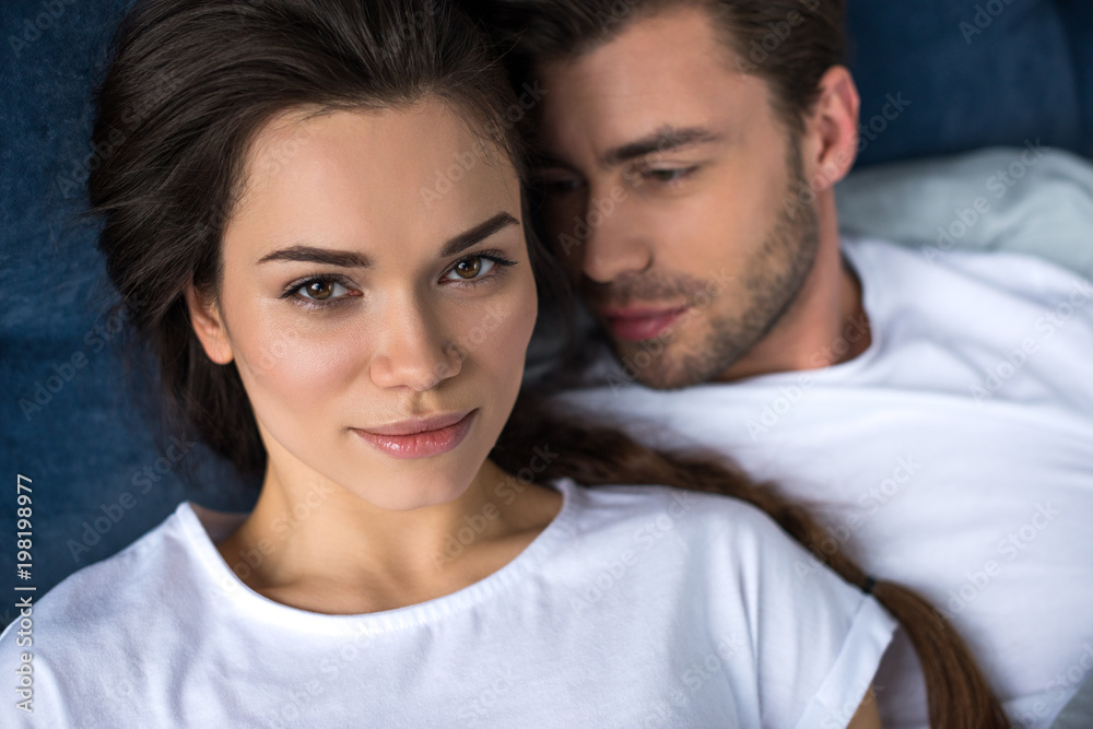 Romantic couple lying on bed in their room Romantic couple lying on bed in their room