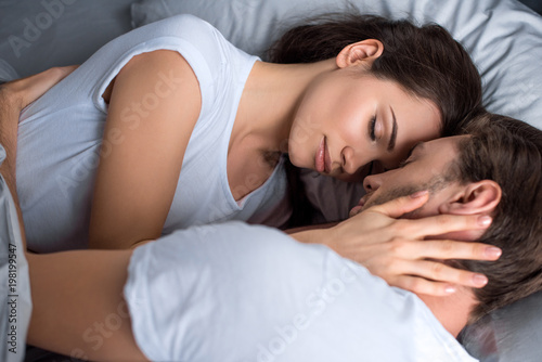 Young woman and man sleeping in bed