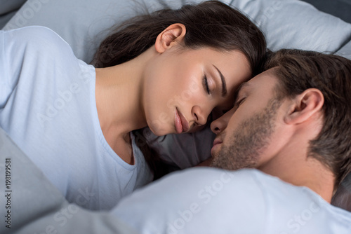 Bearded man and attractive brunette woman sleeping