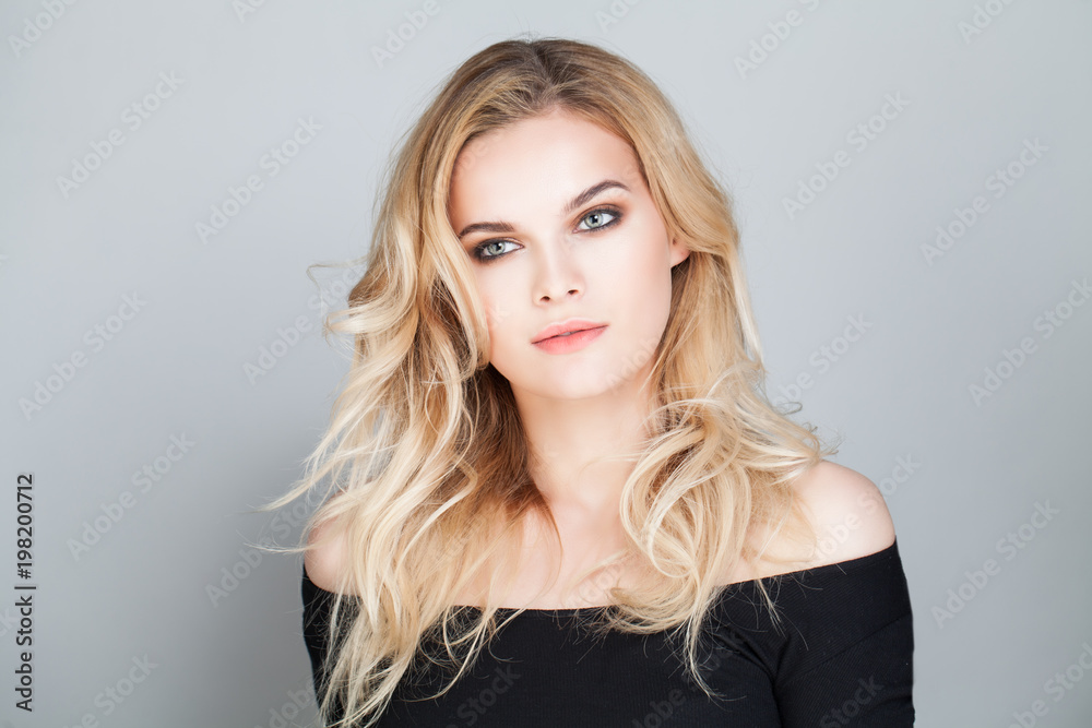 Naklejka premium Blonde Beauty. Beautiful Young Woman with Blonde Curly Hair Portrait