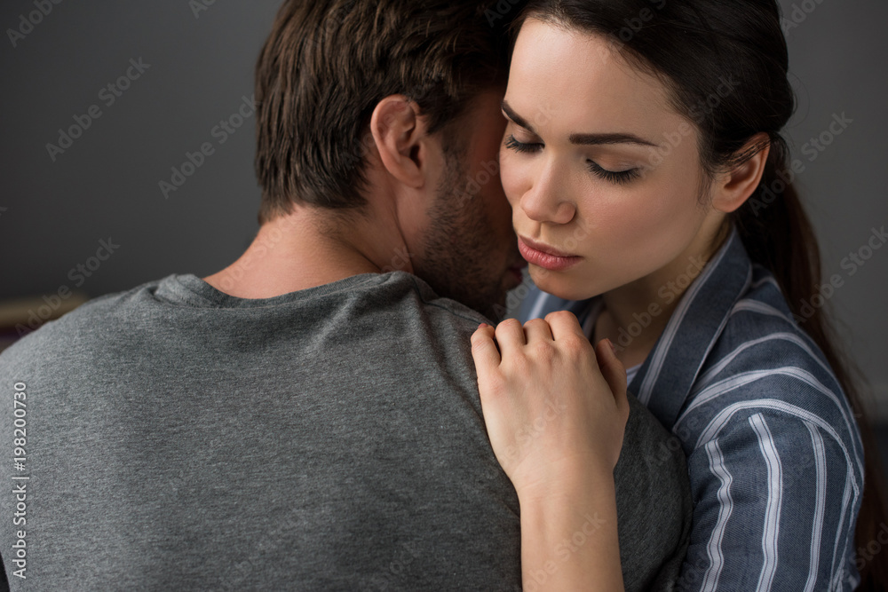Young attractive couple hugging in bedroom Young attractive couple hugging in bedroom