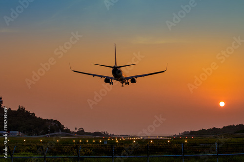Airplane just arrive to the airport ready to landing on the runway at sunset, transportation worldwide for passengers transmission