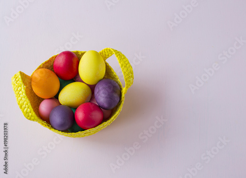 on the table basket with painted eggs - easter background