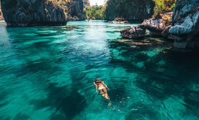 Woman swimming in clear sea water in Asia