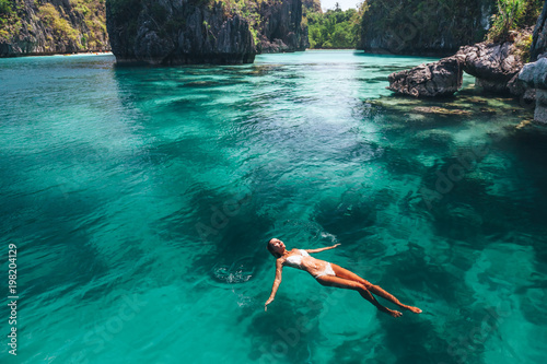Woman swimming in clear sea water in Asia