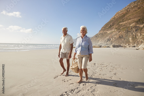 Senior Retired Couple Walking Along Beach Hand In Hand Together © Monkey Business
