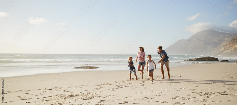 Parents Running Along Beach With Children On Summer Vacation - obrazy, fototapety, plakaty 