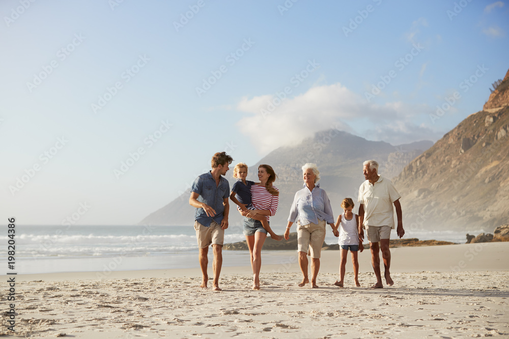 Multi Generation Family On Vacation Walking Along Beach Together Multi Generation Family On Vacation Walking Along Beach Together