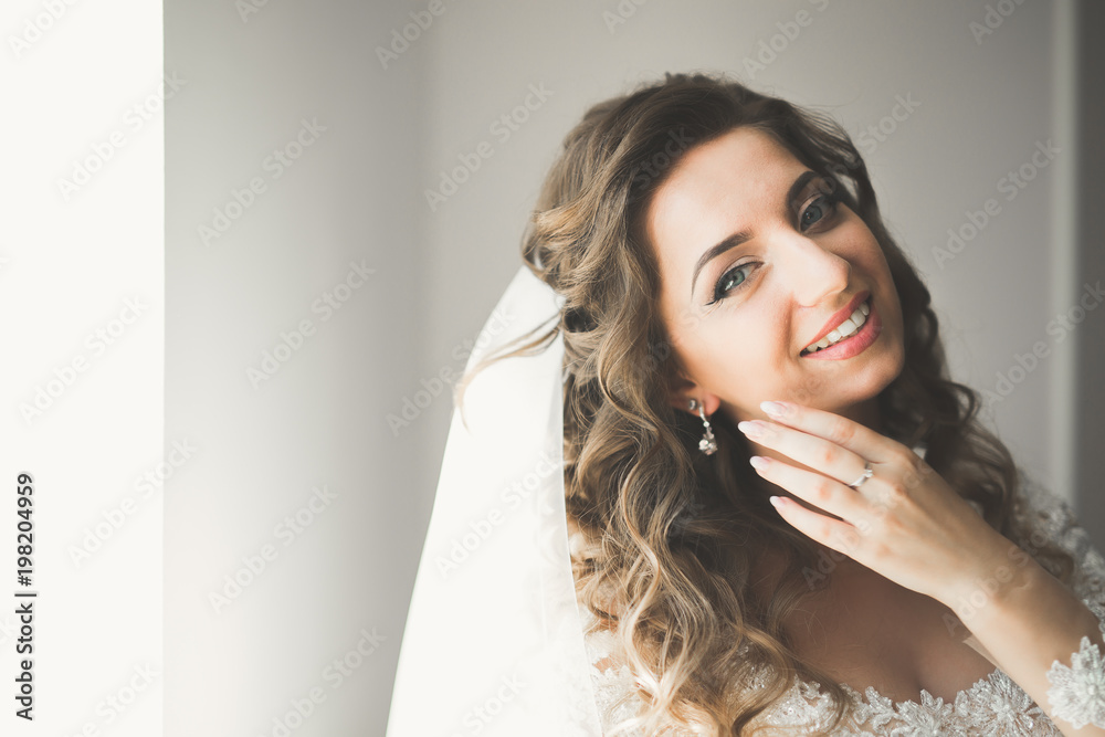 Luxury bride in white dress posing while preparing for the wedding ceremony Luxury bride in white dress posing while preparing for the wedding ceremony