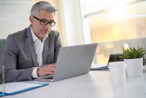 Businessman in office working on laptop