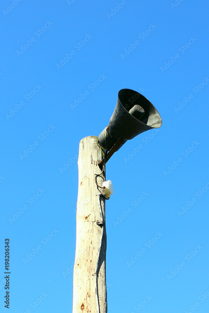 Fototapeta premium Horn Information carrier on a pole, sky background, Shooting from below