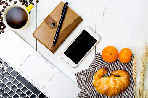 top view business breakfast with coffee and croussant. Rustic white wooden background with copy space photo