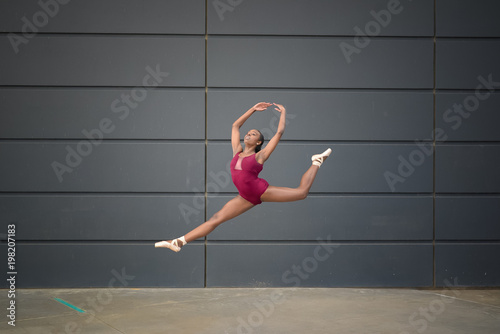 Girl wearing a leotard and ballet slippers and leaping photo