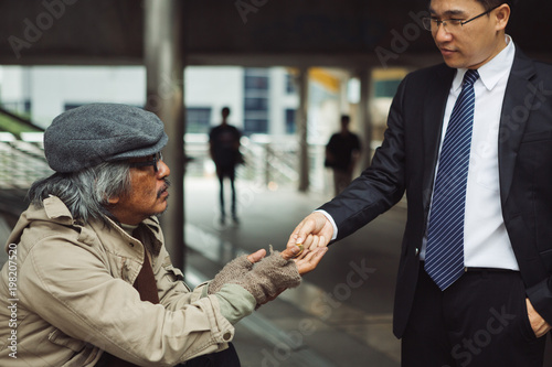 Business man give a money to homeless people