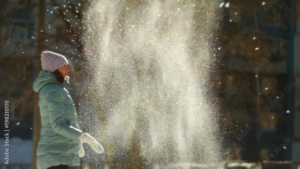 SLOW MOTION: Happy young woman playing with snow SLOW MOTION: Happy young woman playing with snow