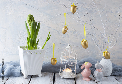 Easter background: hyacinth, painted golden eggs and two Easter bunnies