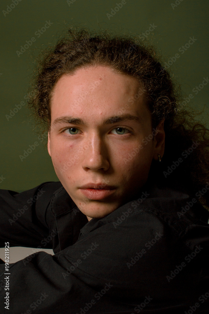 Fototapeta premium Attractive and stylish guy with curly hair and a sports figure