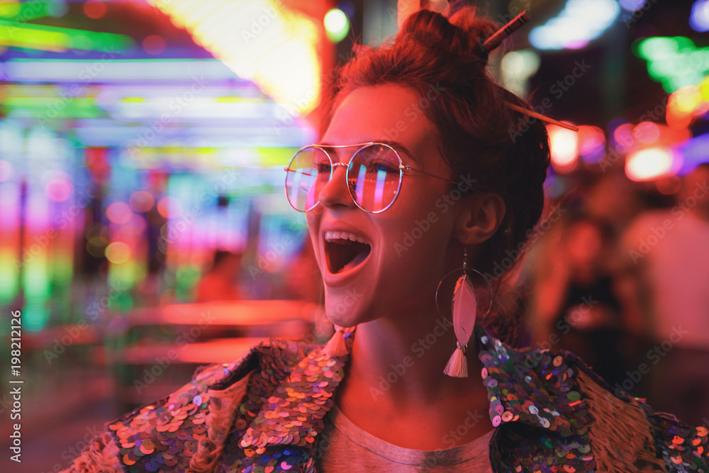 Εκτύπωση καμβά Woman wearing sparkling jacket on the city street with neon lights