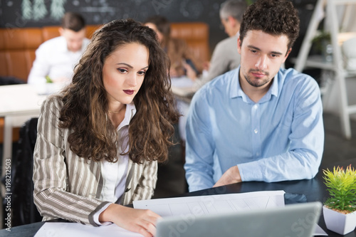 Young colleagues working together in a cafe