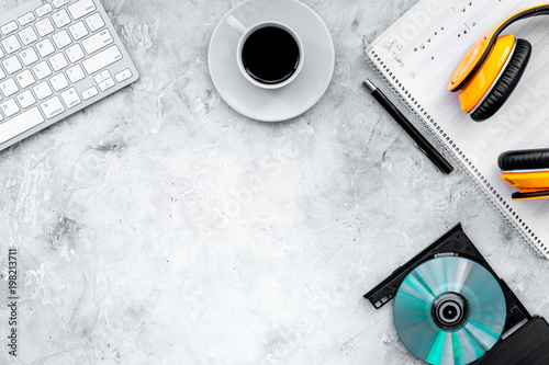 Work desk of modern composer. Music notes near headphones on gray background top view copy space photo