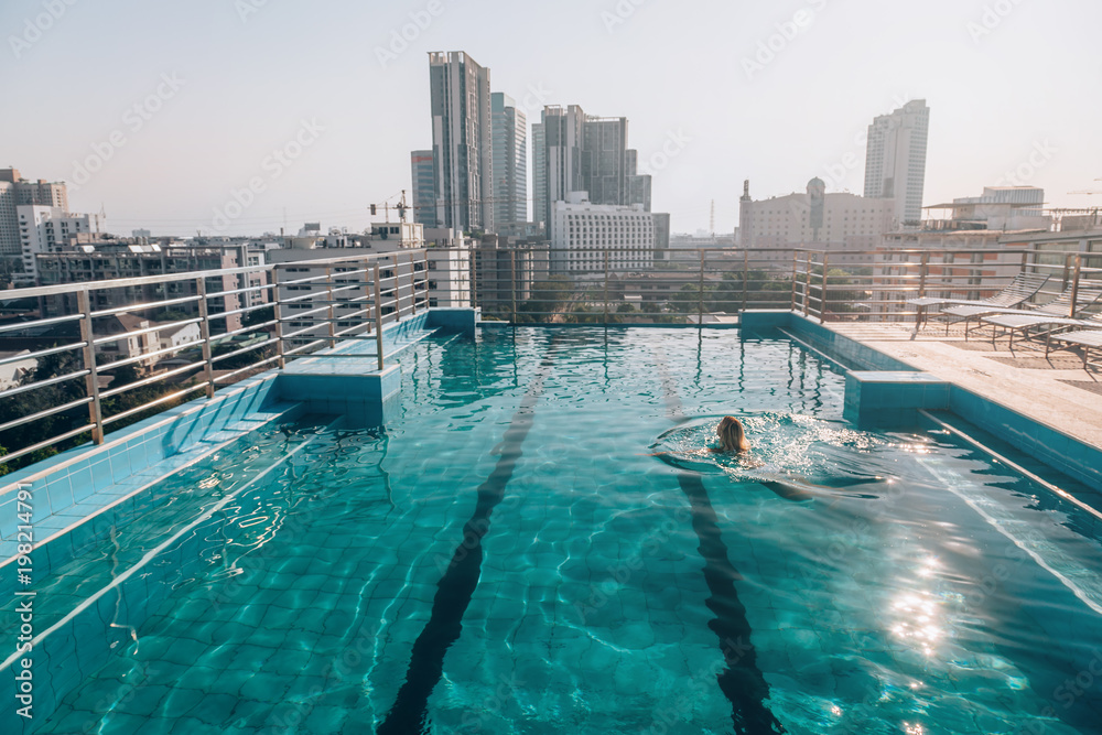 Fototapeta premium Kobieta pływanie w basenie na dachu