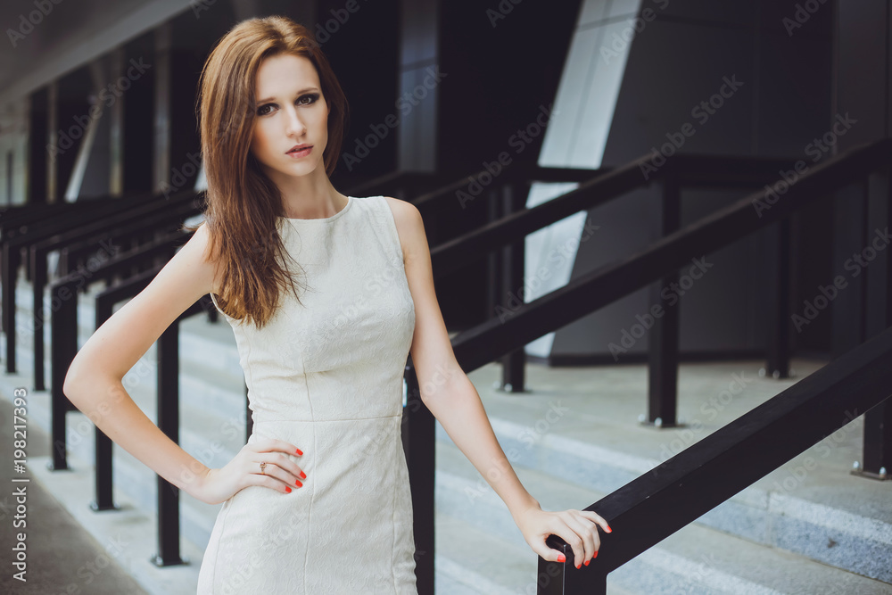 Young beautiful girl with a brown-haired woman in a beige dress, walking, walking along a street, a city and posing. Fashion photo