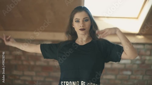 beautiful athletic girl in black dancing vogue or hip hop and jumping. Woman throws hair up. closeup shot