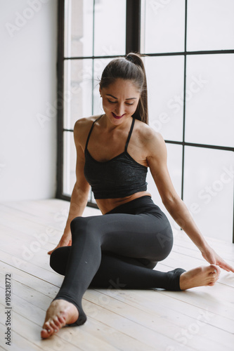 Young woman doing yoga at light window