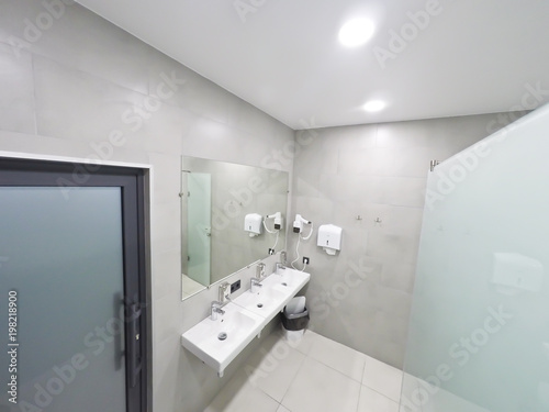 Interior of the bathroom with shower and washbasins in the modern office of the business center