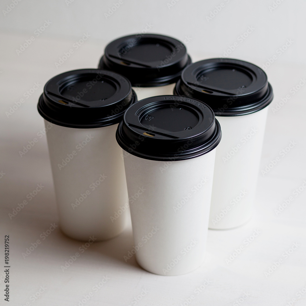 Coffee in blank white paper cups takeaway with caps. on white background. Coffee in blank white paper cups takeaway with caps. on white background.